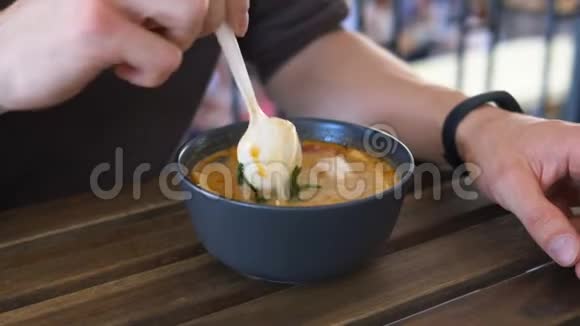 男人在黑碗里喝汤坐在棕色的咖啡馆里视频的预览图