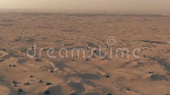 傍晚阿联酋迪拜附近沙漠中的沙丘空中小车变焦镜头视频的预览图