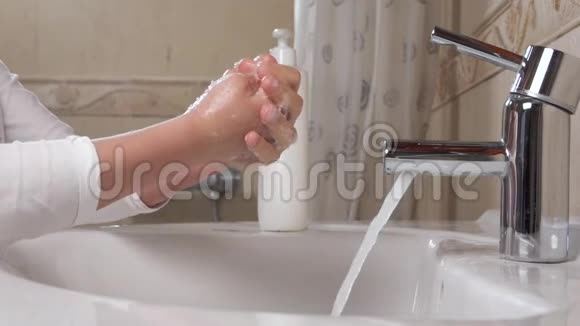 预防冠状病毒COVID19洗手孩子用自来水和肥皂洗手视频的预览图