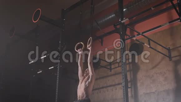 一个身材好的年轻人在健身房的运动环上做肌肉锻炼视频的预览图