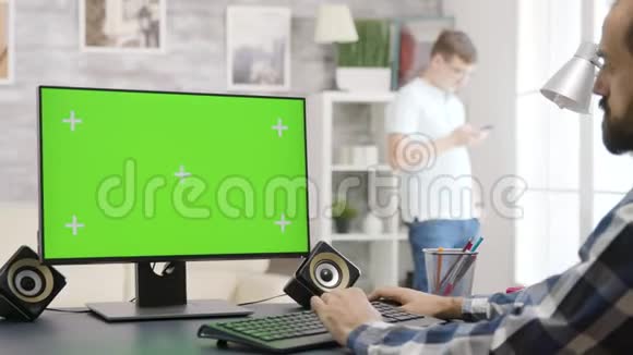 在绿色屏幕上工作的人的肩膀上拍摄隔离的模拟显示器视频的预览图