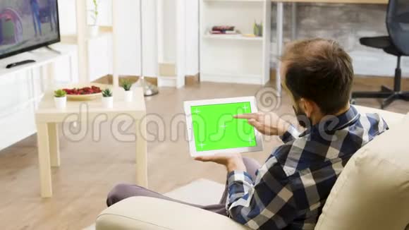 手持绿色屏幕数字平板电脑的人视频的预览图