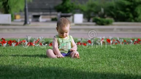 可爱的小宝宝在草地或绿草上慢慢爬行一个小孩子世界慢动作4K视频的预览图