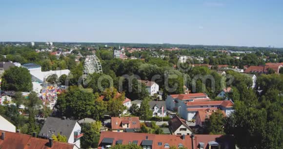 摩天轮在德国小镇的房屋和树木之间的集市视频的预览图