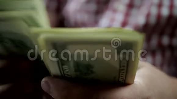 双手在黑暗中数美元钞票视频的预览图