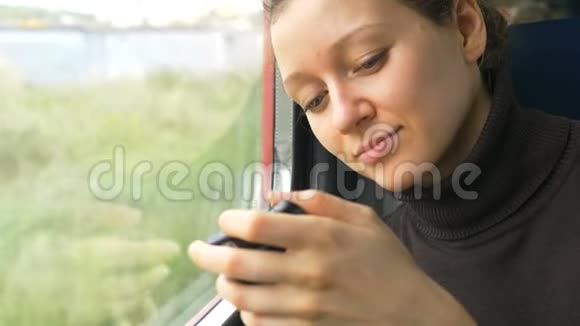 年轻漂亮的女人看现代智能手机显示器视频的预览图