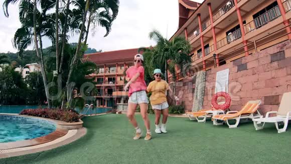 在热带度假胜地年轻的女人正在同步跳舞视频的预览图