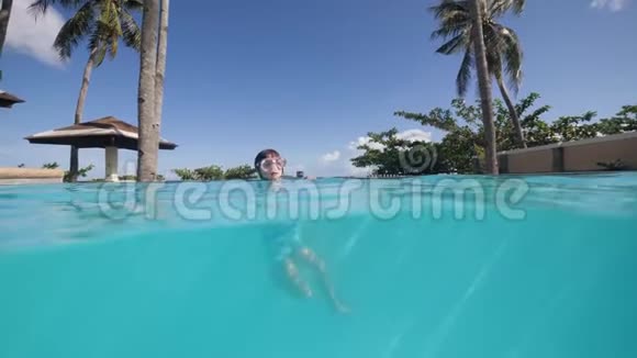 小女孩在水下潜水戴着潜水面罩在游泳池里狗在照顾她视频的预览图