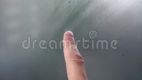 一根手指在雾蒙蒙的窗户上画出一颗心雨天玻璃上的浪漫标志视频的预览图