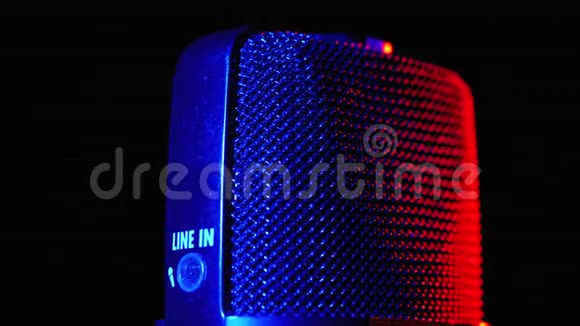 冷凝器麦克风旋转与蓝色和红色背光专业音频录音机特写视频的预览图