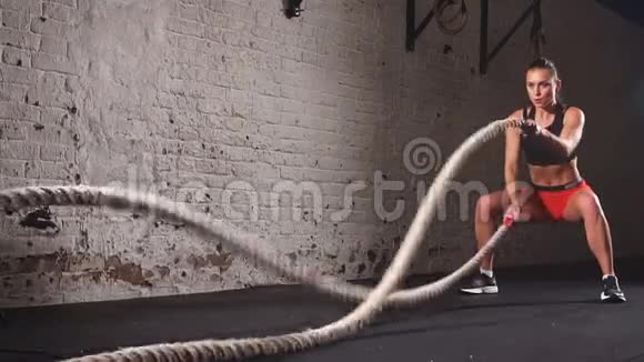运动女性锻炼与战斗绳索作为她的健身健身房锻炼的一部分视频的预览图