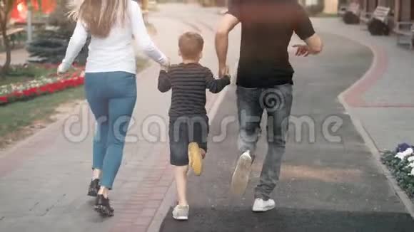 带着孩子的父母向前跑幸福的一家人在公园里玩视频的预览图