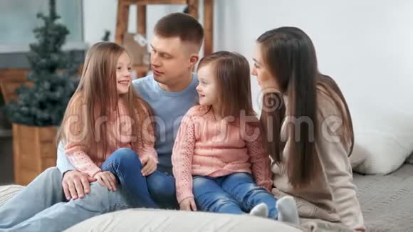 幸福的一家人在一起交谈一起微笑在圣诞树的背景下有积极的情绪视频的预览图