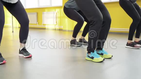 健身俱乐部里蹲着的女人的腿的特写集体培训健康生活方式视频的预览图