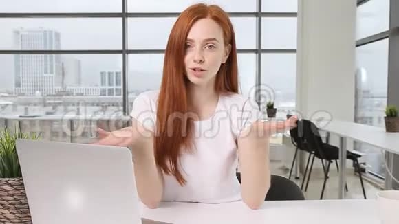 快乐的红发女孩在摄像机上进行在线训练表情和手势视频的预览图