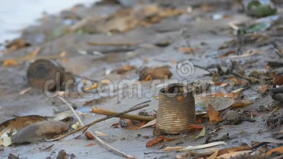 一个满是生锈的罐子和破瓶子的水库脏兮兮堵塞的岸边视频的预览图