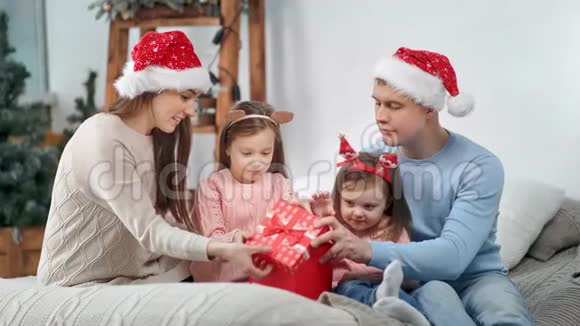 惊艳幸福一家人在喜庆的服装中一起打开礼盒庆祝圣诞节视频的预览图