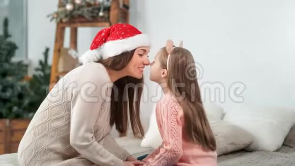 幸福的家庭妈妈和可爱的女儿笑着摸鼻子庆祝圣诞节视频的预览图