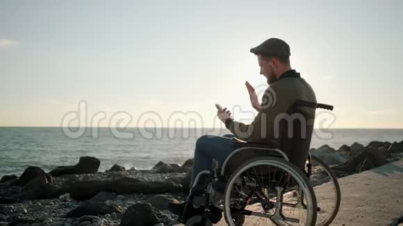 在海上坐在轮椅上的智能手机上人类通过视频通话视频的预览图