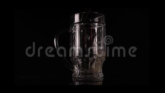 啤酒倒在黑色背景上的玻璃杯里视频的预览图