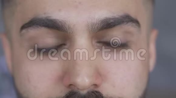 极端的特写迷人的棕色眼睛男人胡子和胡子看相机一个英俊的男人的肖像视频的预览图