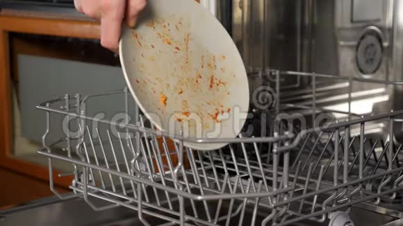 人们把脏盘子和餐具放进洗碗机的特写镜头视频的预览图