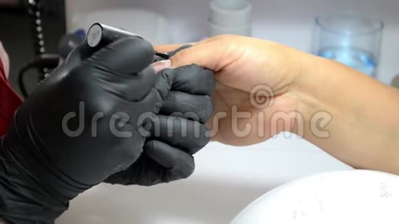 戴黑色手套的指甲油师傅在指甲上涂指甲油视频的预览图