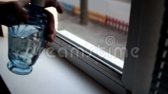 男人在家里洗窗户用洗水喷雾和除尘器清洗窗户视频的预览图