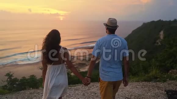 情侣手牵手去悬崖看美丽的夕阳慢动作视频的预览图