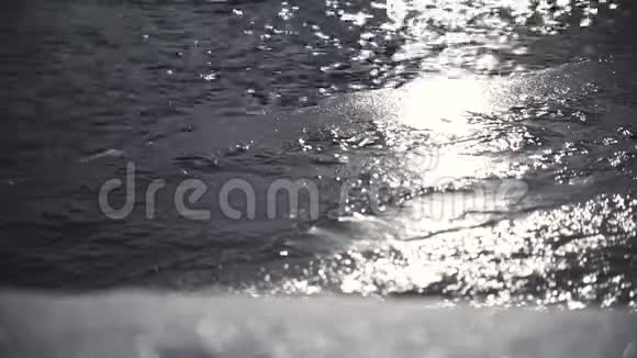 冬天水和冰在阳光下闪闪发光水的暗色特写镜头视频的预览图
