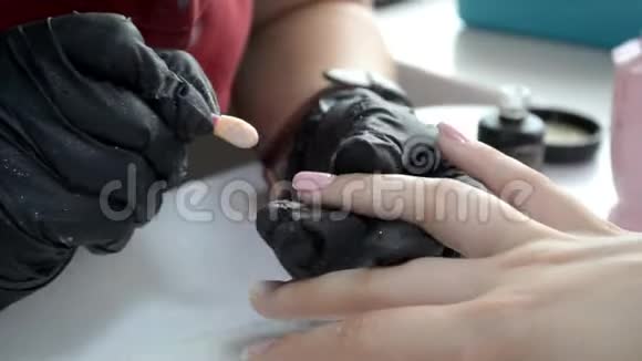美甲师在指甲上涂上一层粉红色的凝胶视频的预览图