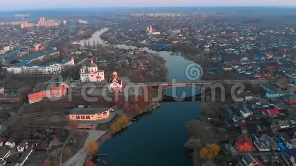 欧洲小城市的河上桥和两座教堂的空中拍摄视频的预览图