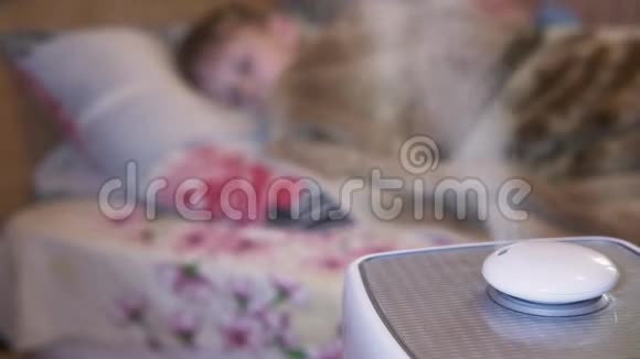 蒸汽从加湿器和空气电离器在一个模糊的房间与一个睡眠小孩子用于增加印度河的气候装置视频的预览图