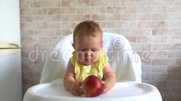 小女孩吃苹果坐在厨房的椅子上儿童营养食品视频的预览图