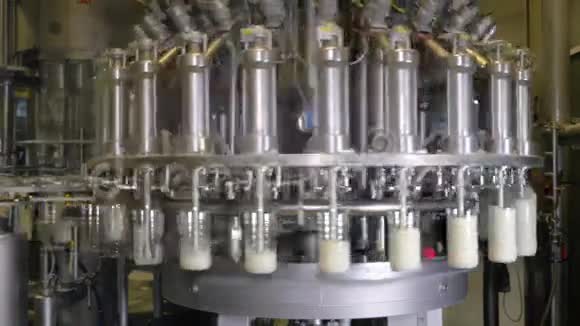 牛奶倒入牛奶生产工厂的工业设备上的瓶子视频的预览图