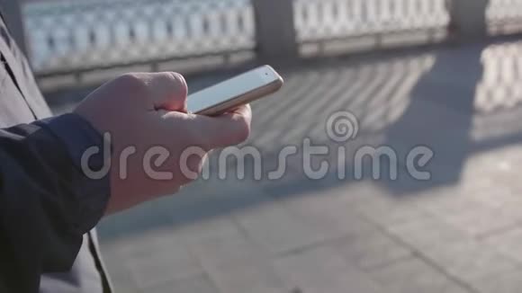 一个年轻人走在街上用电话上网特写镜头视频的预览图