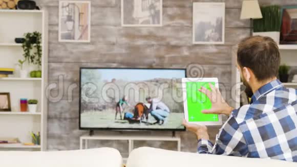 坐在沙发上拿着平板电脑的留胡子男人的后景视频的预览图