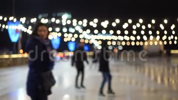 在这个城市的中心广场上模糊的溜冰场上人们在新年假期里溜冰视频的预览图
