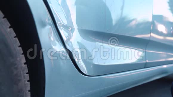 一只雌性的手在一辆破车的车门上摸索着一个凹痕检查裂缝和油漆碎片用手指按压评估视频的预览图