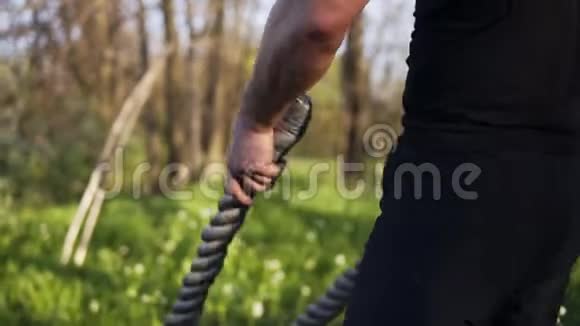 一只雄性手臂挥舞着战绳的镜头克罗斯菲特培训春天的时候室外视频的预览图