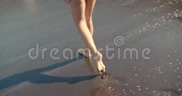 沙滩上的女人腿女孩走在海边的沙滩上视频的预览图