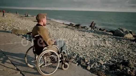 身体底层瘫痪的成年男子坐在海边放松身心视频的预览图