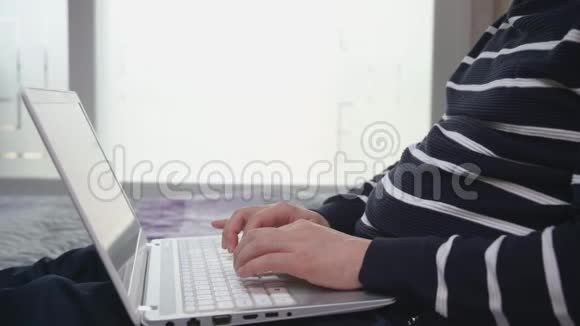 亚洲中年男子使用笔记本电脑从家里远程办公视频的预览图