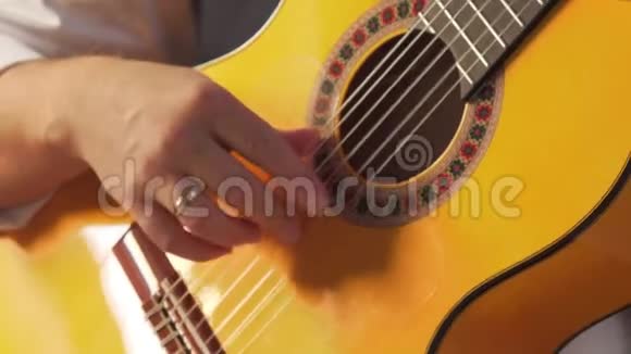 穿着白色衬衫的男人弹古典吉他特写视频的预览图