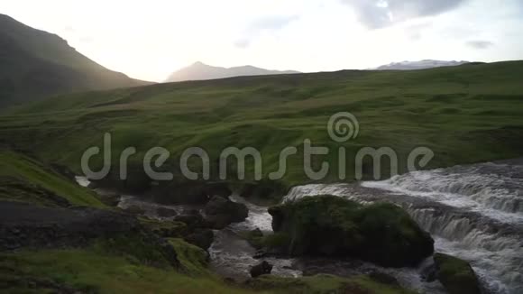 在Fimvorduhals日落时美丽的平滑的冰岛河缓慢地运动周围是青山视频的预览图