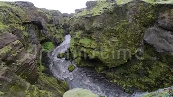 美丽的河流在冰岛峡谷周围的绿色悬崖上的Fimvorduhals徒步旅行轨道视频的预览图