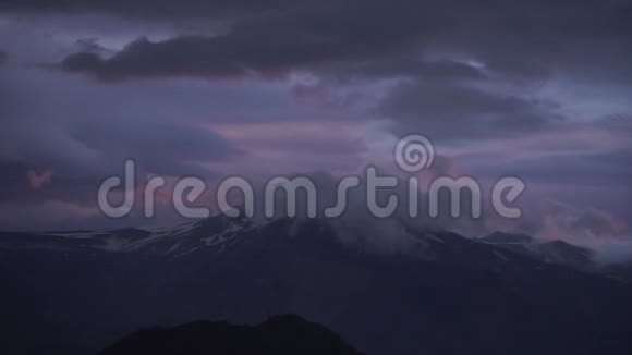 在戏剧性的五彩缤纷的日落中有雪和云的山峰视频的预览图