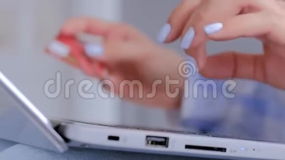使用手提电脑键盘和信用卡进行网上购物的女性视频的预览图