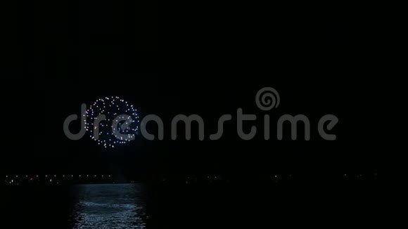 夜空中明亮的节日烟火映在水面上视频的预览图