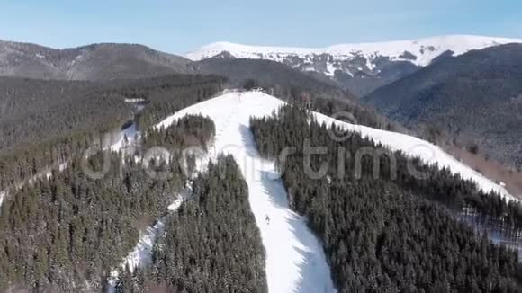 滑雪场上有滑雪者和滑雪升降机的空中滑雪斜坡雪山森林视频的预览图